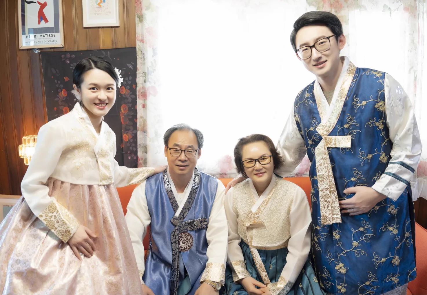 A family portrait arranged around the orange sofa inside Botong Lee Studio