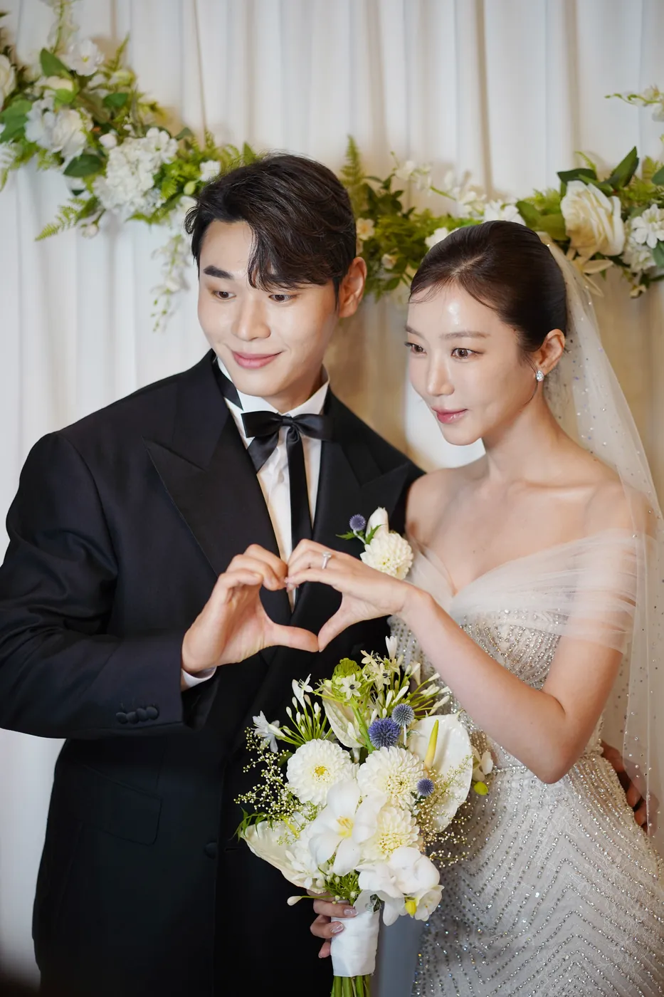 손으로 하트를 만드는 신랑 신부